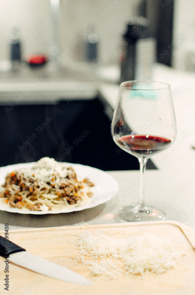 Pasta bolognese with a glass of pinotage red wine. Wine from the Pinotage grape variety. Italian cuisine at home. Dishes of Italian cuisine with your own hands.