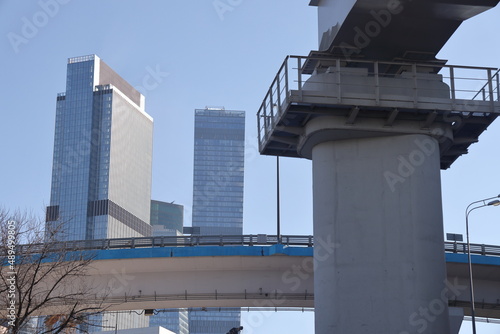 Overpasses on the background of skyscrapers. Blue sky and bright sun. Transport interchanges and urbanism. photo