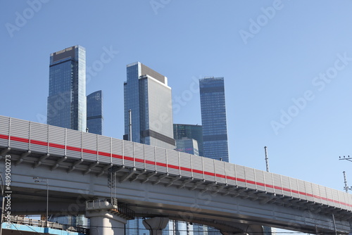 Overpasses on the background of skyscrapers. Blue sky and bright sun. Transport interchanges and urbanism. photo