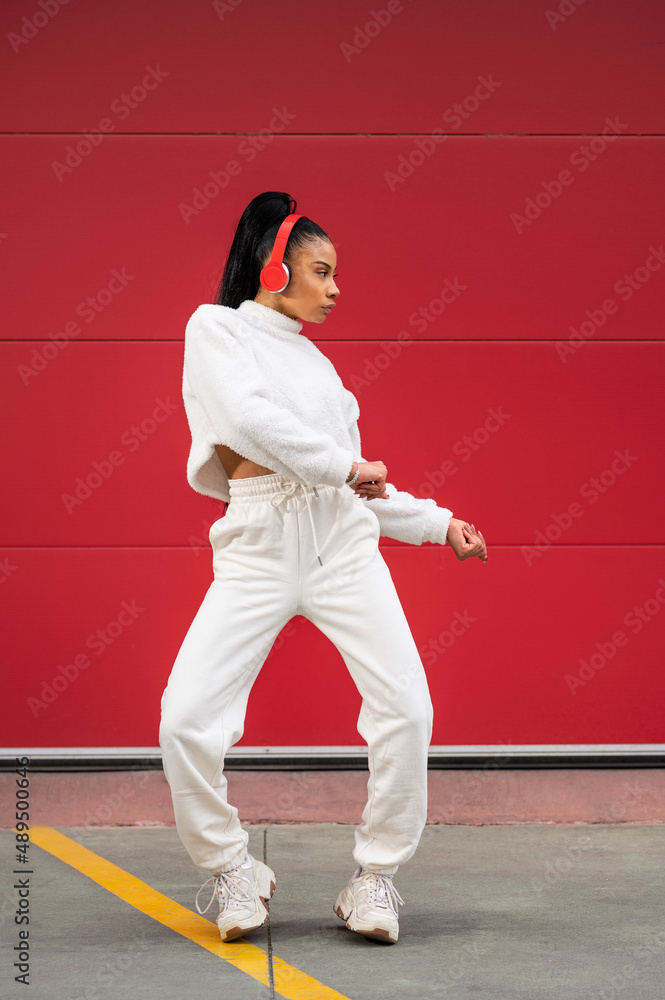 Cheerful African American woman with headphones
dancing urban dance on a red background Cheerful African American woman with headphones
dancing urban dance on a red background