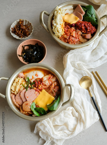 Delicious homemade Korean gourmet. Budae jjigae aka Army Stew with Banchan Side Dishes. Popular South Korean meals influenced by American during the Korean War.