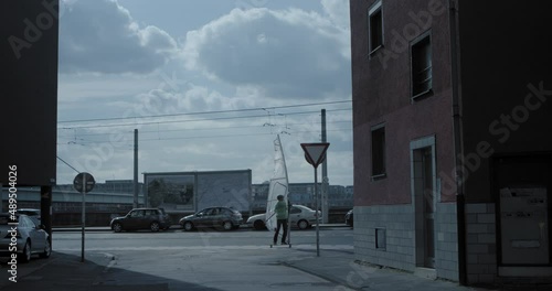 Urban wind skating between houses. Modern lifestyle. Surprising appearance of the skater.