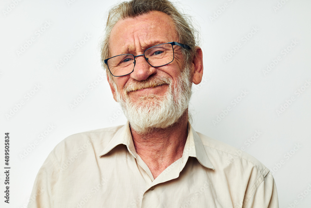 Obraz premium Portrait of happy senior man with a gray beard in a shirt and glasses isolated background