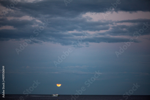 Bateau au loin au coucher de soleil avec la mer et l'horizon