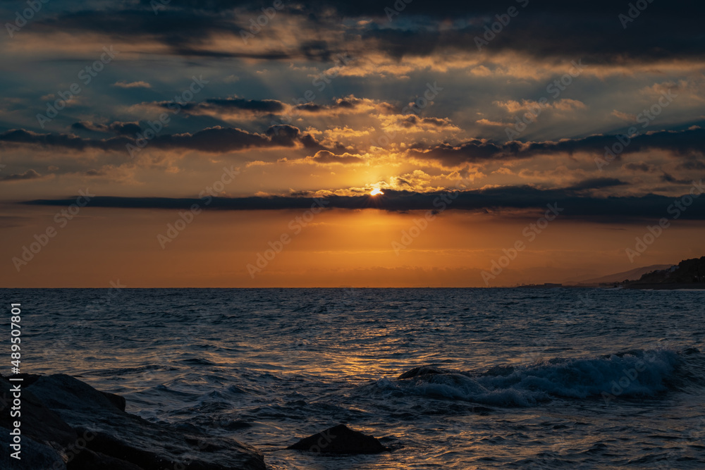 Sea against picturesque golden cloudy sky sunset on an amazing beach wallpaper