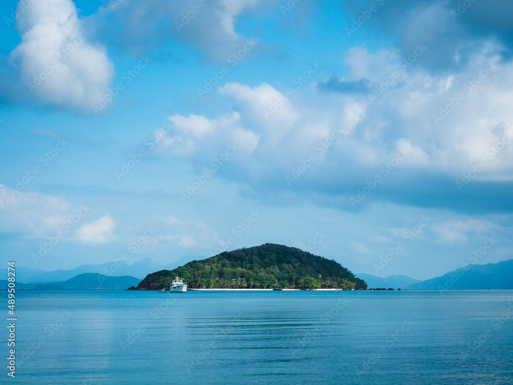 Scenic view of Koh Kham Island in the middle of peaceful bay against cloudy blue sky. Shot from Koh Mak Island, Trat, Thailand. Minimal background.
