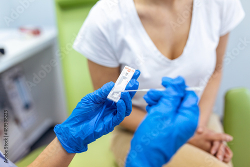 Shot of a doctor using cotton swab while doing coronavirus PCR test at the hospital. Doctor laboratory assistant takes swab from patient. doctor with protective glove taking coronavirus rapid test
