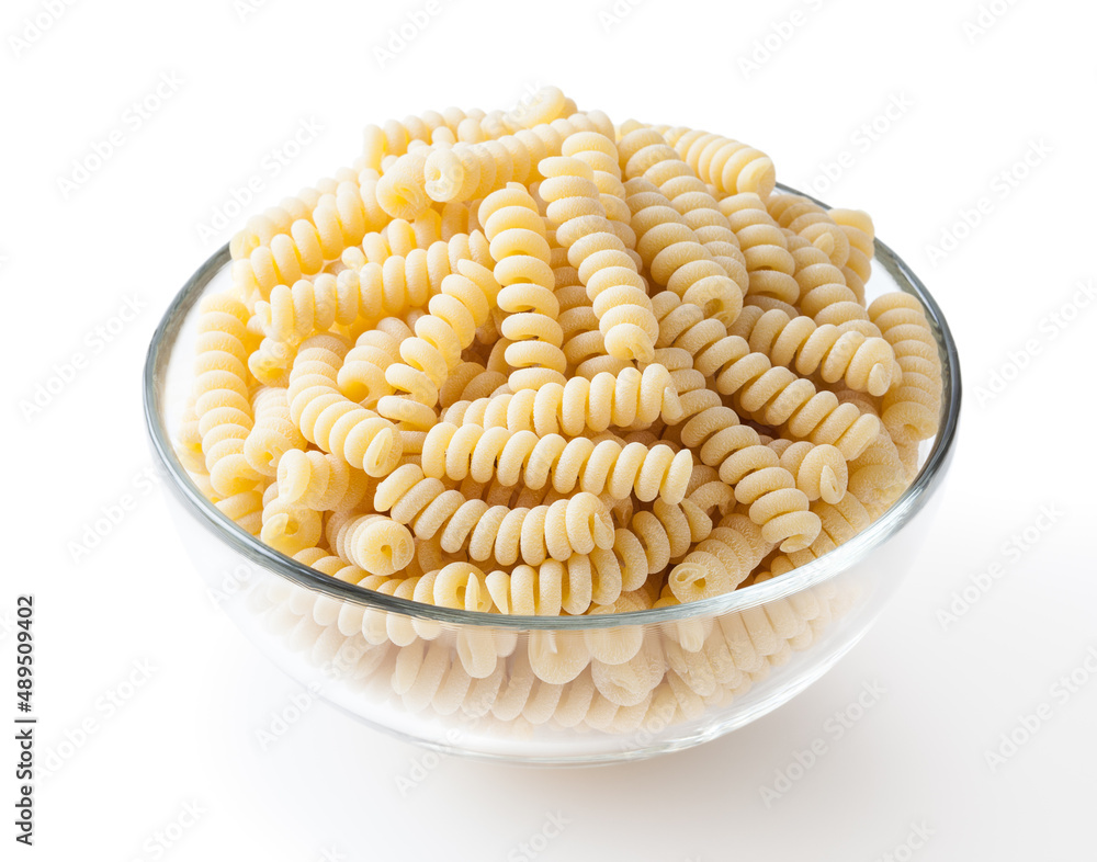 Uncooked fusilli corti bucati pasta in glass bowl isolated on white background with clipping path Uncooked fusilli corti bucati pasta in glass bowl isolated on white background with clipping path