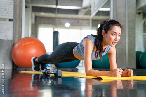 Healthy Asian athlete woman in sportswear do plank workout exercise body weight lifting at fitness gym. Strong female body building muscle weight training at sport club. Health care motivation concept © CandyRetriever 