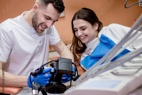 The dentist shows the patient a picture of the result of treatment. Satisfied patient