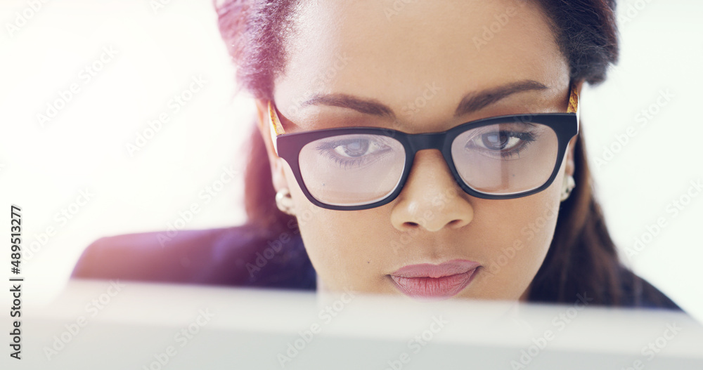 Shes a very focused individual. Cropped shot of an attractive young businesswoman working on her computer in the office. Shes a very focused individual. Cropped shot of an attractive young businesswoman working on her computer in the office.