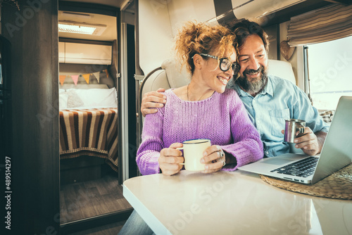 Camper van traveler enjoy and use laptop computer together inside camper van rv. Modern people and roaming internet connection technlology. Smart working and vanlife lifestyle photo