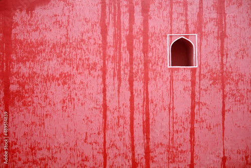Traditional Indian style wall decor on a red wall wet with raindrops
