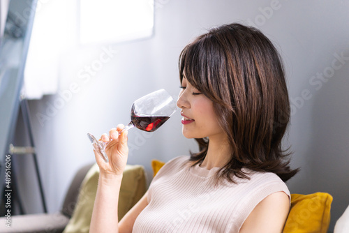 家でワインを楽しむ若い女性