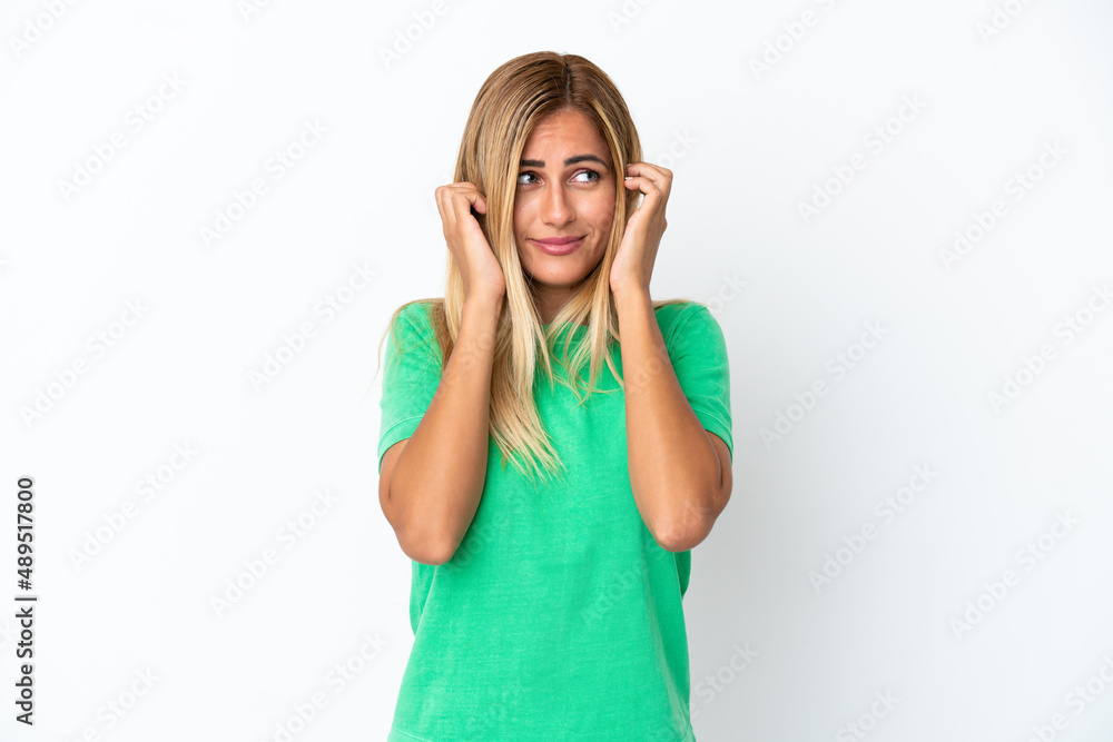 Blonde Uruguayan girl isolated on white background frustrated and covering ears Blonde Uruguayan girl isolated on white background frustrated and covering ears