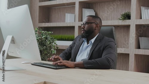 African American in a business suit CEO at his workplace get frustrated and angry looking at screen unhappy with the results of the perfomance