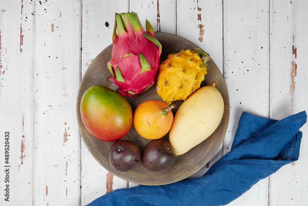 Exotic fruits, tropical fruits mix, healthy food, vegans, wooden table