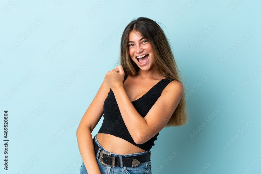 Young caucasian woman isolated on blue background celebrating a victory Young caucasian woman isolated on blue background celebrating a victory