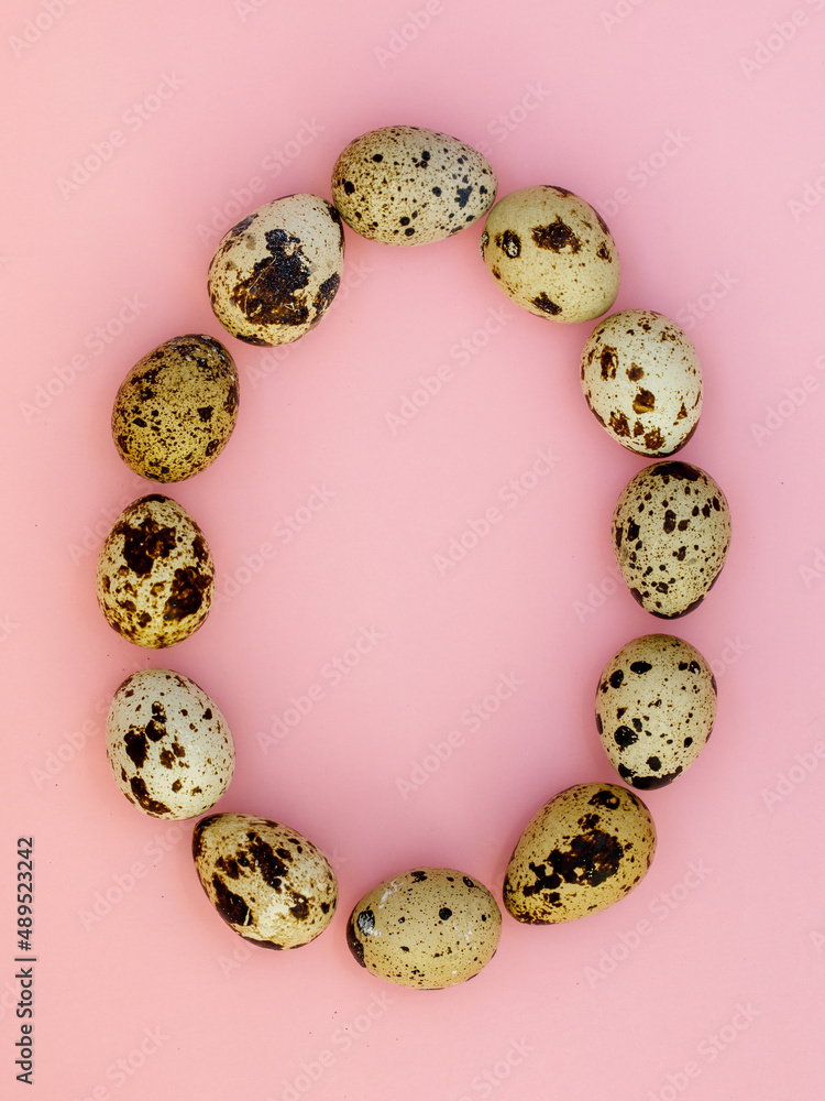 Creative Easter egg shaped layout made of quail eggs on pink background. Top view flat lay, copy space. Vertical Creative Easter egg shaped layout made of quail eggs on pink background. Top view flat lay, copy space. Vertical