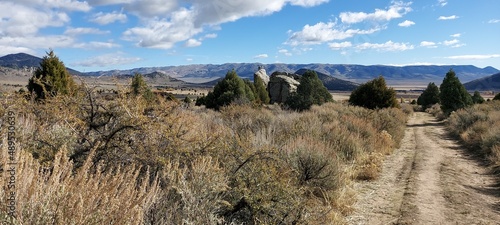 A country road leading across the plain to the mountains against the backdrop of the autumn sky.