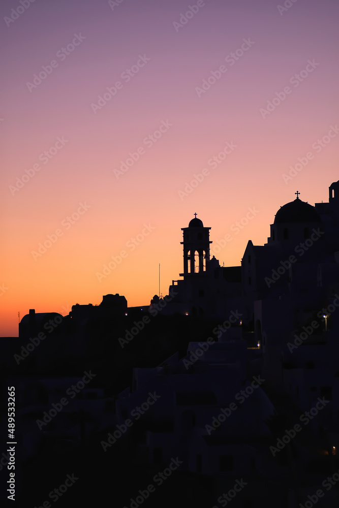 Fototapeta premium Amazing golden sunset and silhouette view of churches and the village of Imerovigli in Santorini
