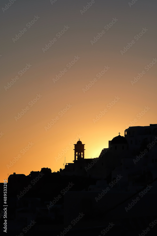 Amazing golden sunset and silhouette view of  churches and the village of Imerovigli in Santorini