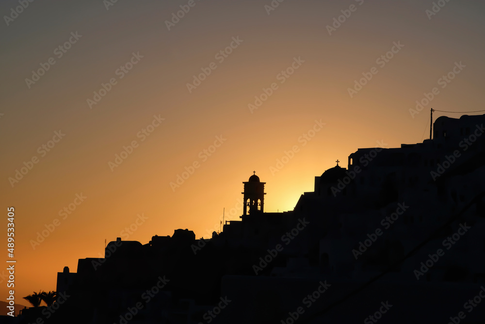 Amazing golden sunset and silhouette view of  churches and the village of Imerovigli in Santorini