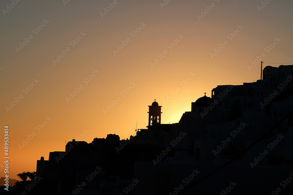 Obraz premium Amazing golden sunset and silhouette view of churches and the village of Imerovigli in Santorini