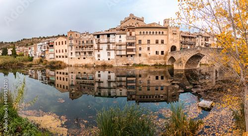 Valderrobres old town reflected on the river at autmn, Roman bridge over the river. Valderrobres, Matarraña, Teruel, Aragon, Spain. Panoramic picture. photo
