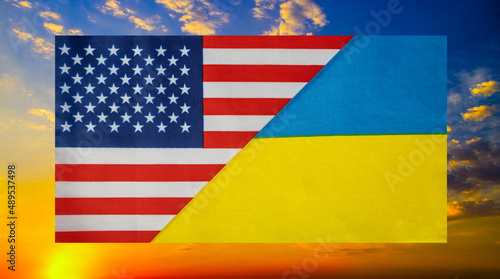 State flags of the USA and Ukraine against the background of a burning sky close-up. Flags.