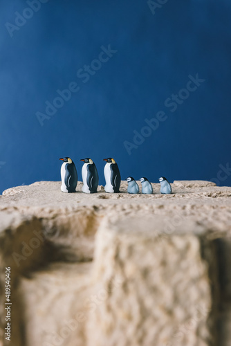 Cute miniature toy penguin colony. Wild animal family.