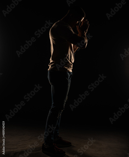 Silhouette of a guy posing in studio while standing