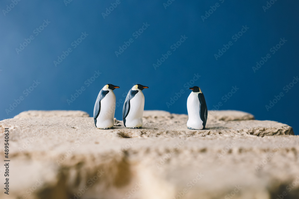 Fototapeta premium Cute miniature toy penguin colony. Wild animal family.