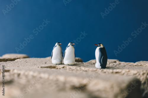 Cute miniature toy penguin colony. Wild animal family.