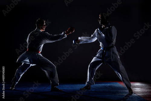 Kata training men isolated on dark background