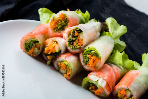 Fresh vegetable salad roll in noodle tube on dish isolated on white background Asian street food