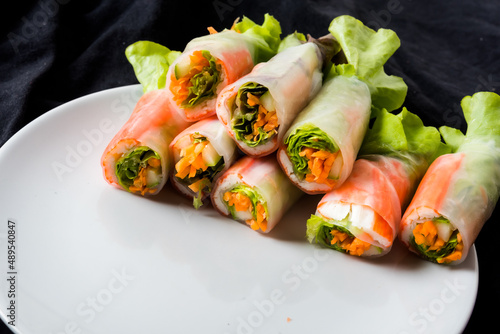 Fresh vegetable salad roll in noodle tube on dish isolated on white background Asian street food