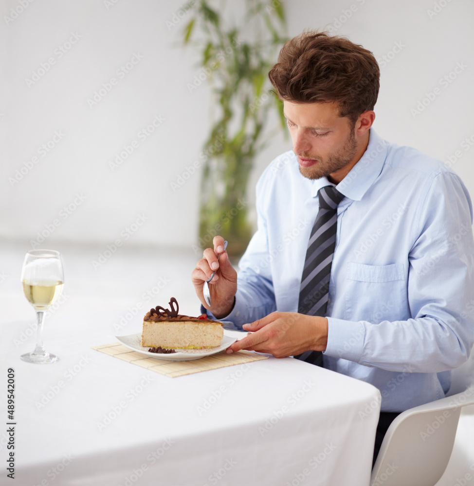 Hes got a sweet tooth. Handsome young man tucking into a delicious piece of cheesecake in a restaurant. Hes got a sweet tooth. Handsome young man tucking into a delicious piece of cheesecake in a restaurant.