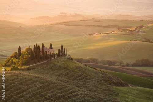 landscape with a famous country house in tuscany at sunrise