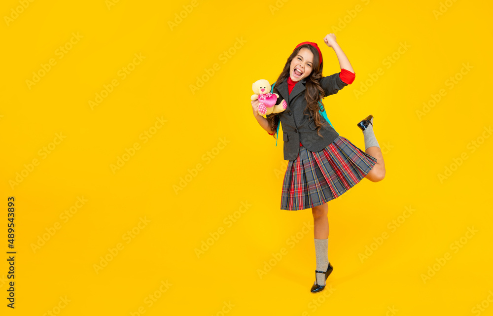 glad kid in school uniform with toy on yellow background, september glad kid in school uniform with toy on yellow background, september