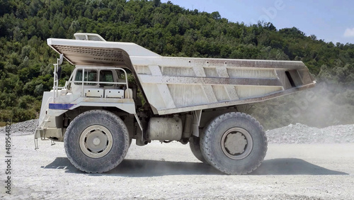 white Haul truck in the quarry, big and large articulated dumping truck, dumper trailer, dump lorry. off-highway heavy-duty construction environment with two axle.