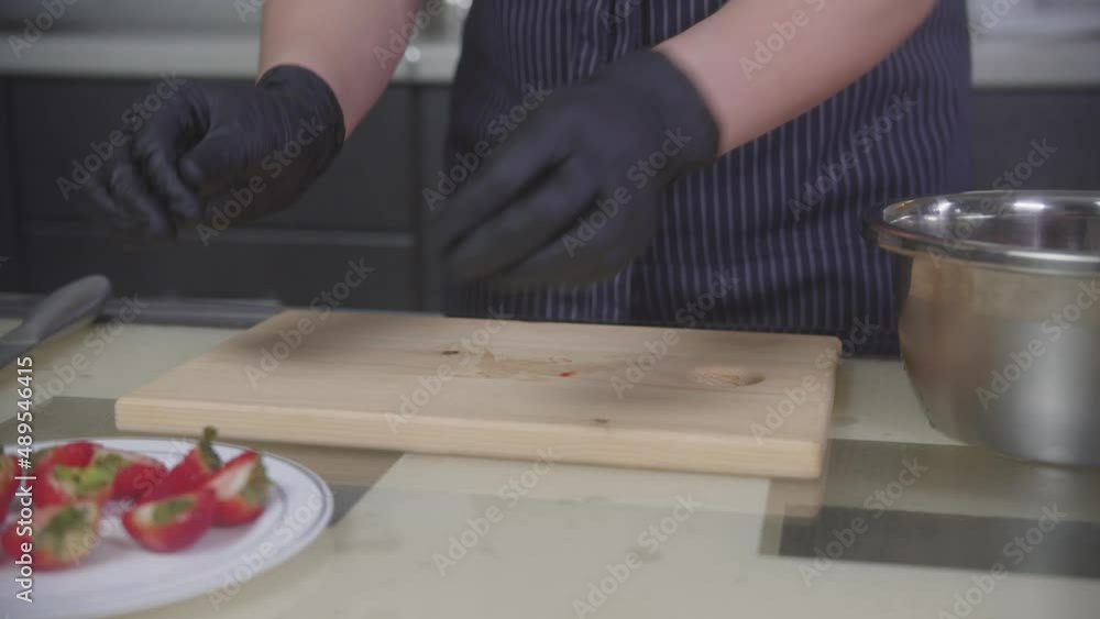 Confectionery - pastry chef cuts strawberries in halves Confectionery - pastry chef cuts strawberries in halves