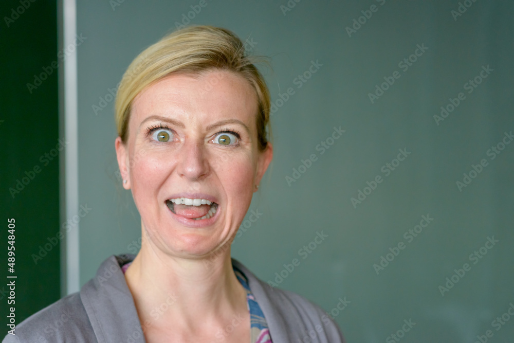 Teacher pulling an aghast face in front of blackboard