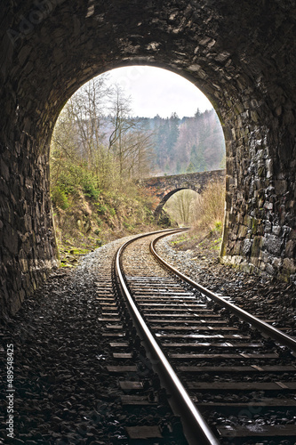 Exit of Vintage train stone tunnel with view on a stone bridge. England style railway travel.