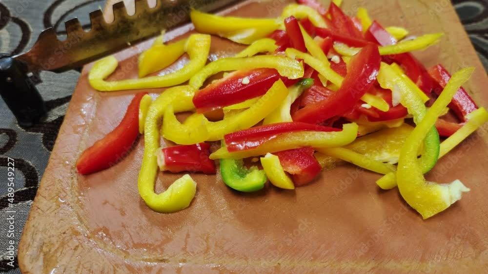 Red and yelllow bell pepper chopped on a plastic vegetable cutter with a stainless steel blade Red and yelllow bell pepper chopped on a plastic vegetable cutter with a stainless steel blade
