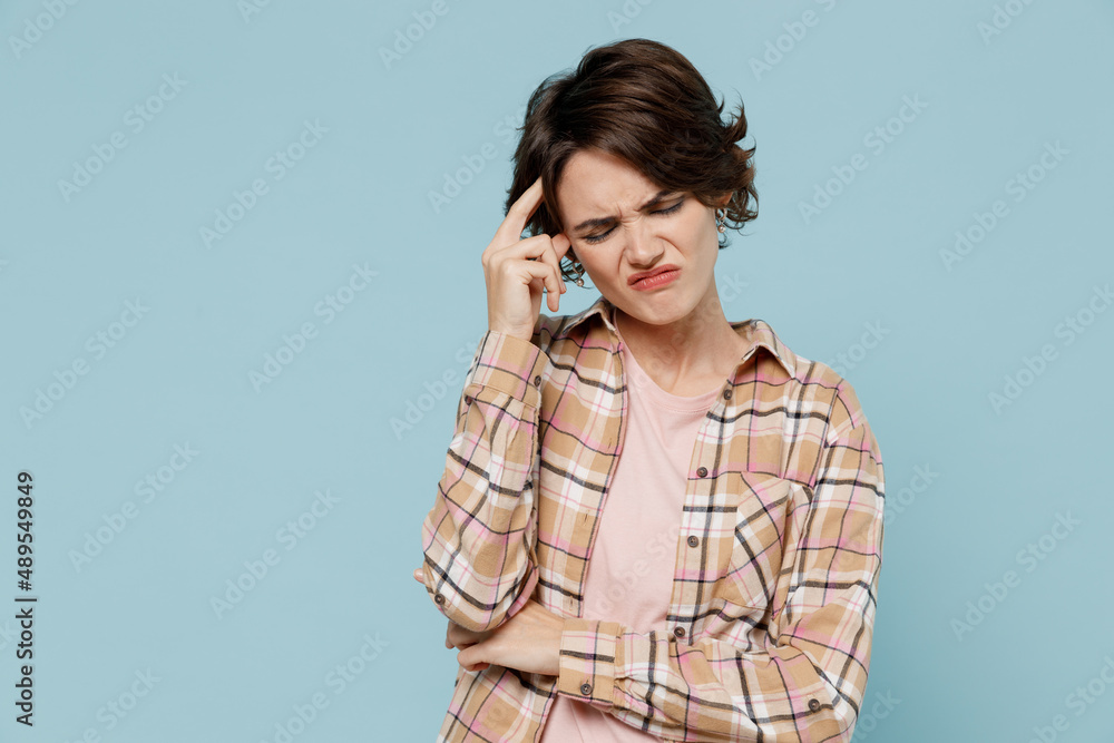 Young thoughtful pensive puzzled caucasian woman 20s wear casual brown shirt think prop up head forehead isolated on pastel plain light blue color background studio portrait. People lifestyle concept. Young thoughtful pensive puzzled caucasian woman 20s wear casual brown shirt think prop up head forehead isolated on pastel plain light blue color background studio portrait. People lifestyle concept.