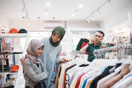 unhappy daughter while shopping new clothes with mother © Odua Images