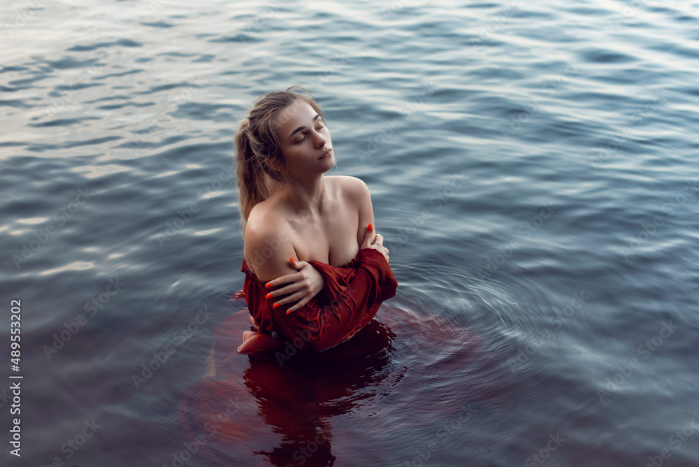 Fototapeta premium Blonde girl bathes in a summer lake