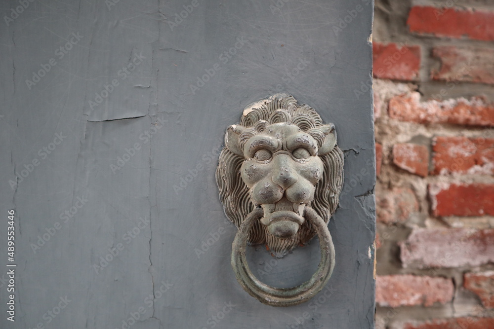 old door knocker of lion on the blue door with retro red brick wall