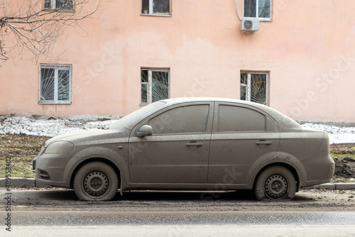 Passenger car completely covered with dirt on a spring city street © Lux pictura